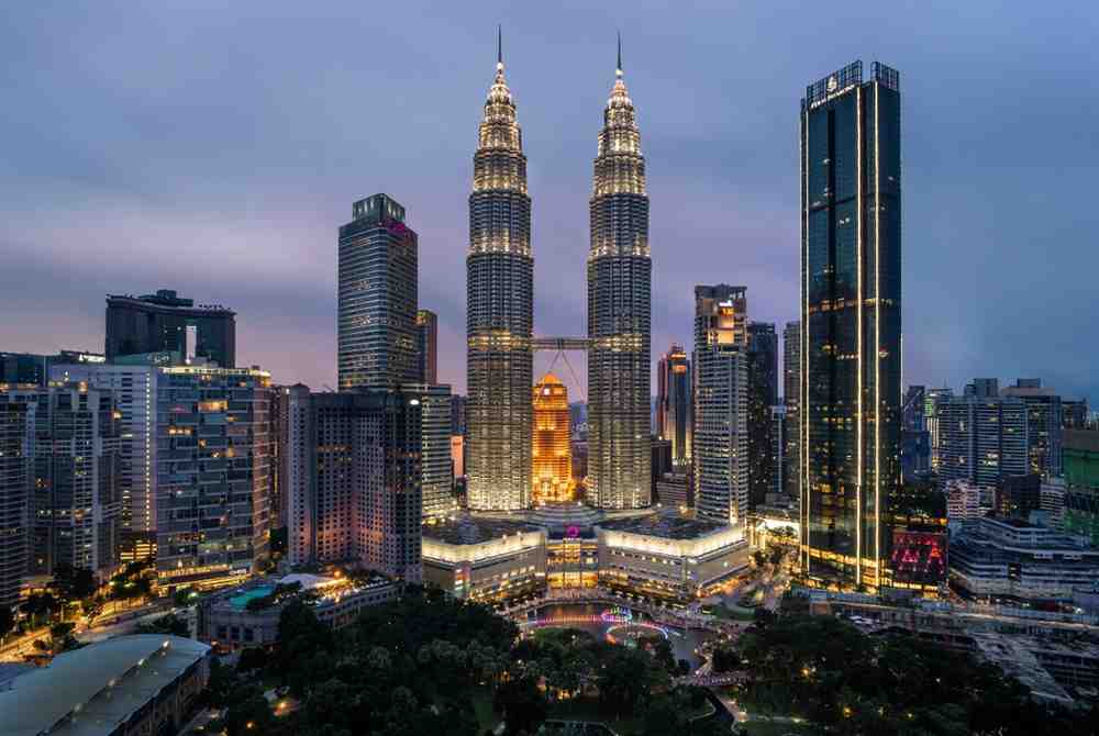 Petronas Twin Towers in Kuala Lumpur illuminated at night – famous Malaysia landmark and top budget travel destination for city views and culture.
