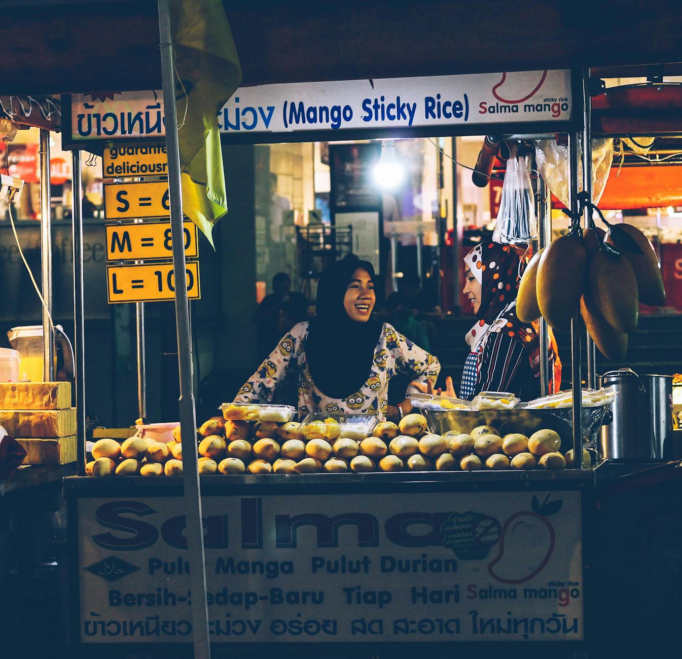 Traditional Thai mango sticky rice dessert served on a street food stall plate in Thailand