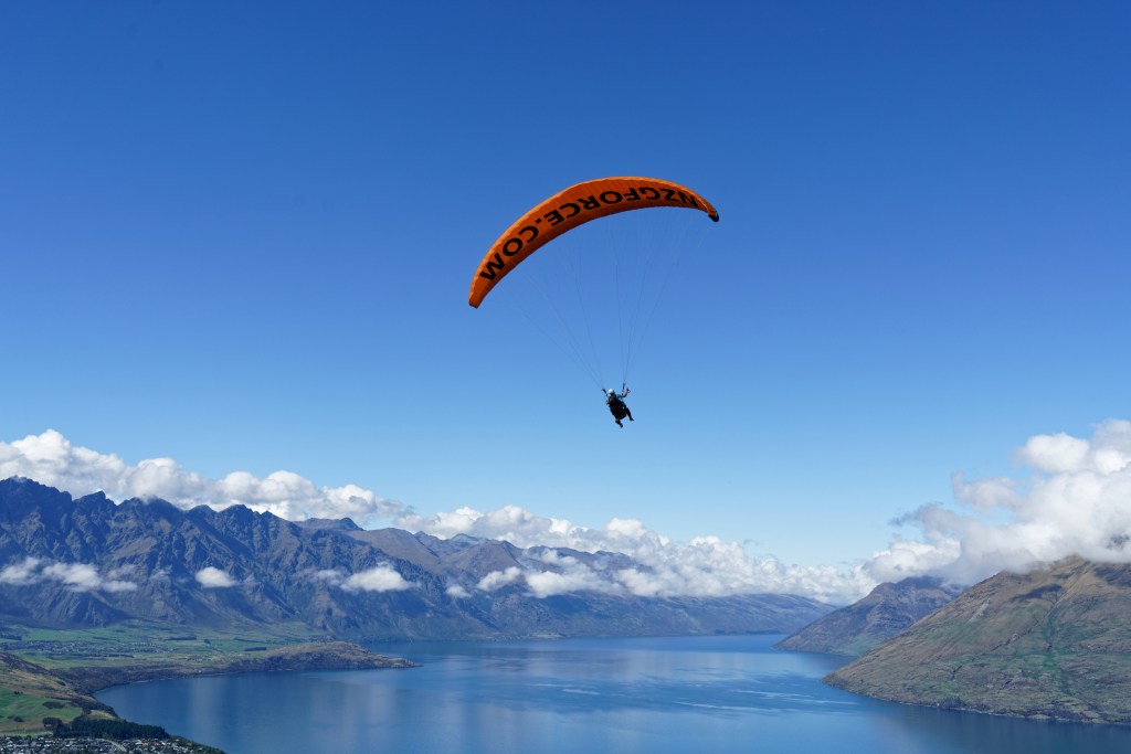 Paragliding over Queenstown with panoramic views of Lake Wakatipu and mountains