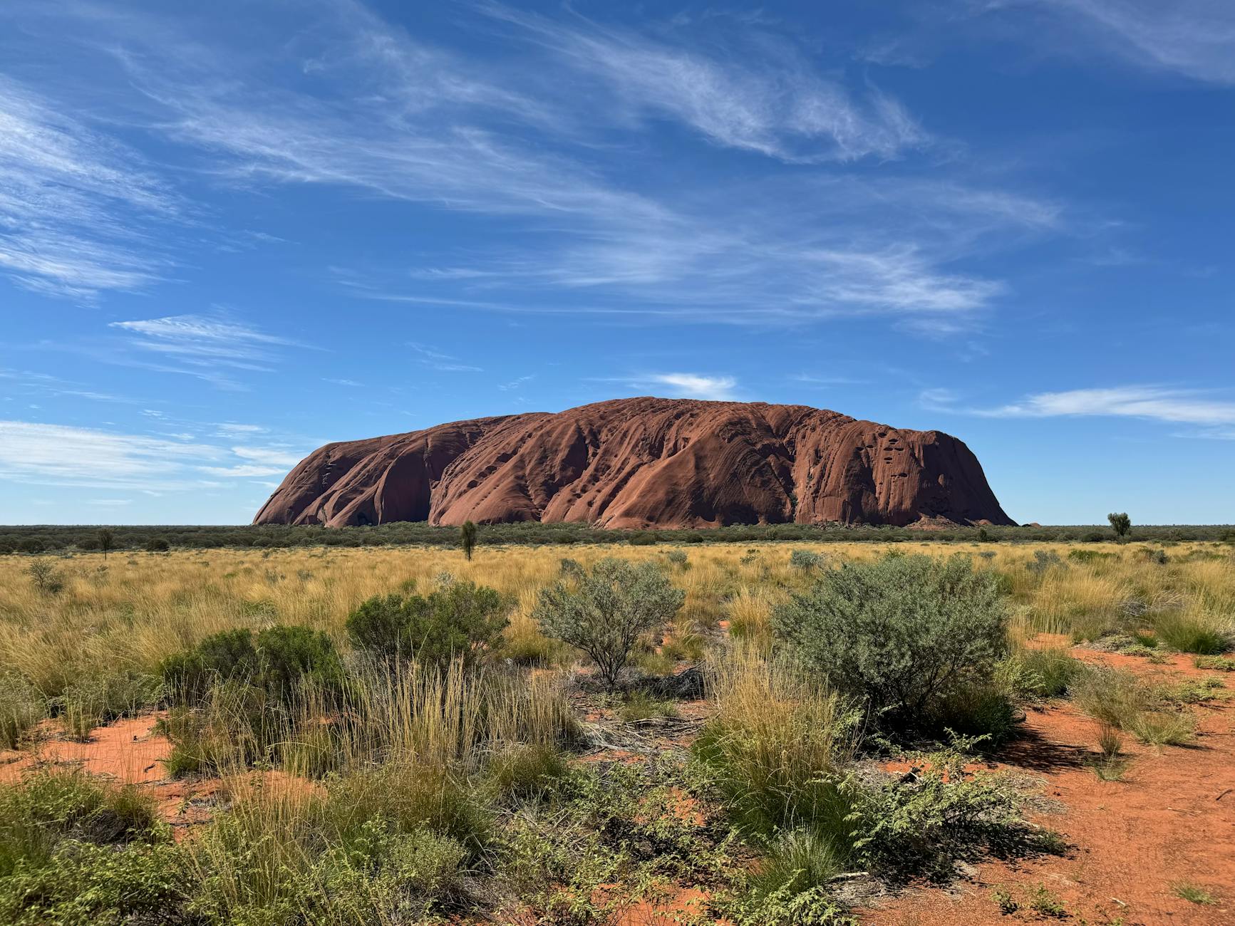Sunrise casting golden light over Uluru in the Australian Outback