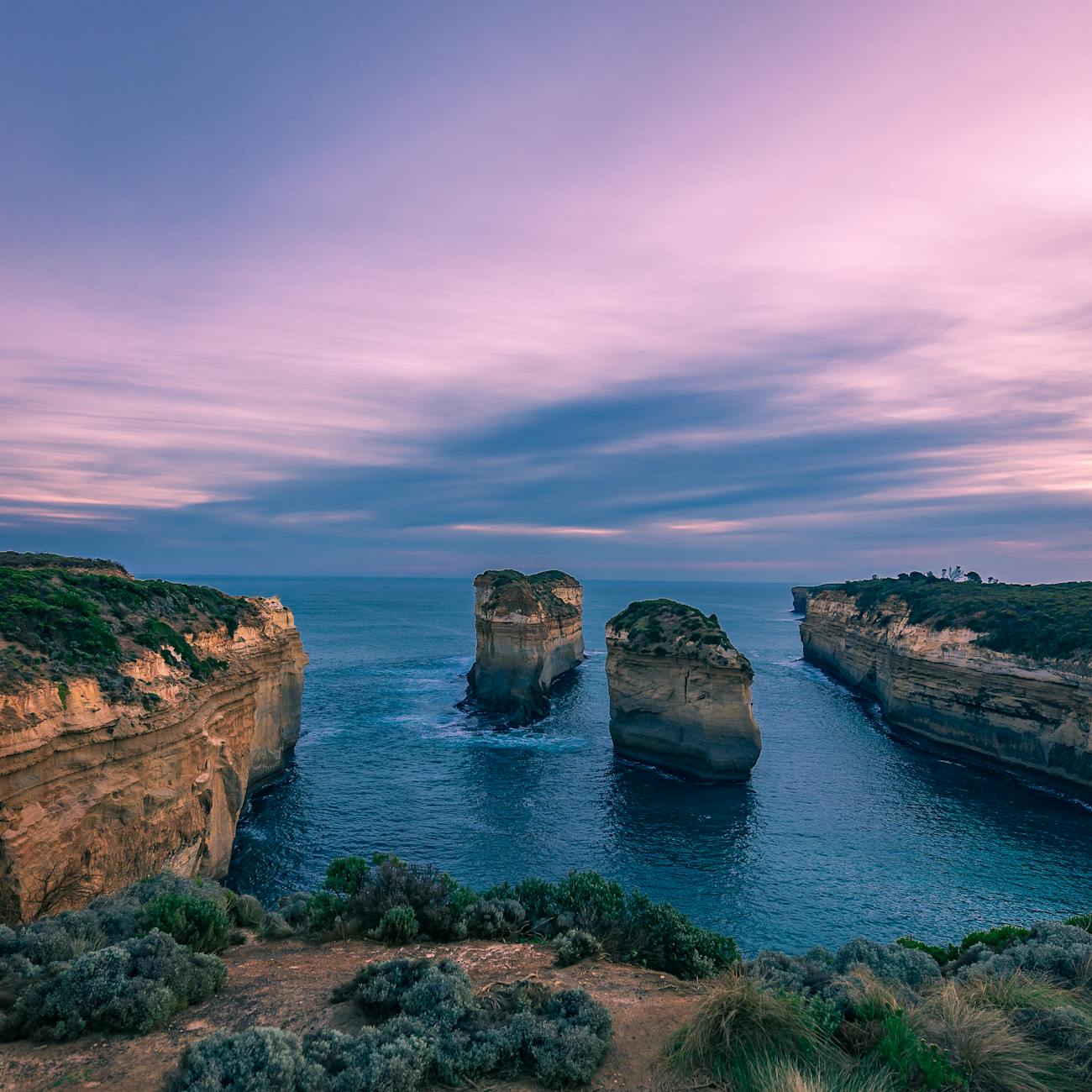Sunset at the Twelve Apostles with golden light over rugged cliffs and ocean