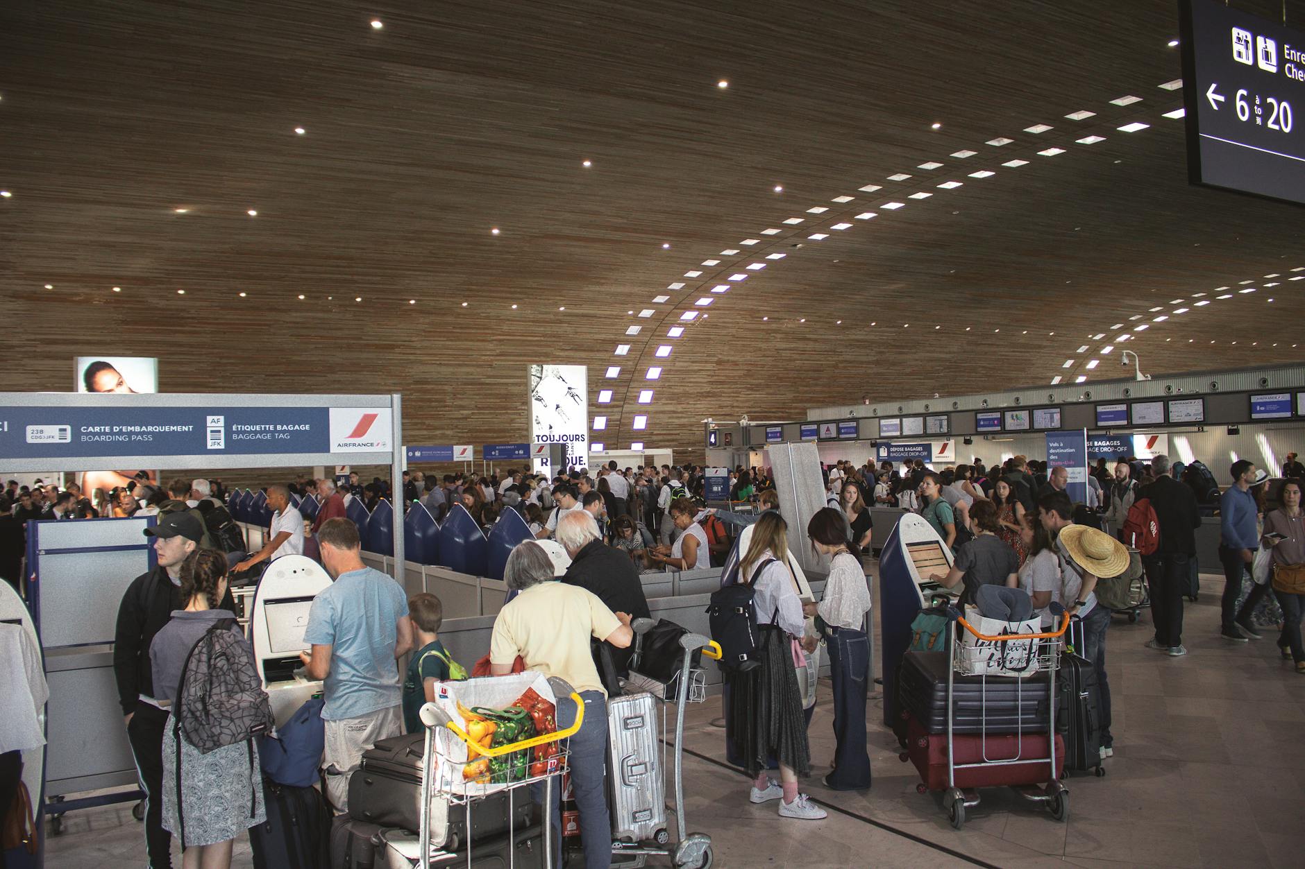 Passengers passing through airport security checkpoint with metal detectors and scanners