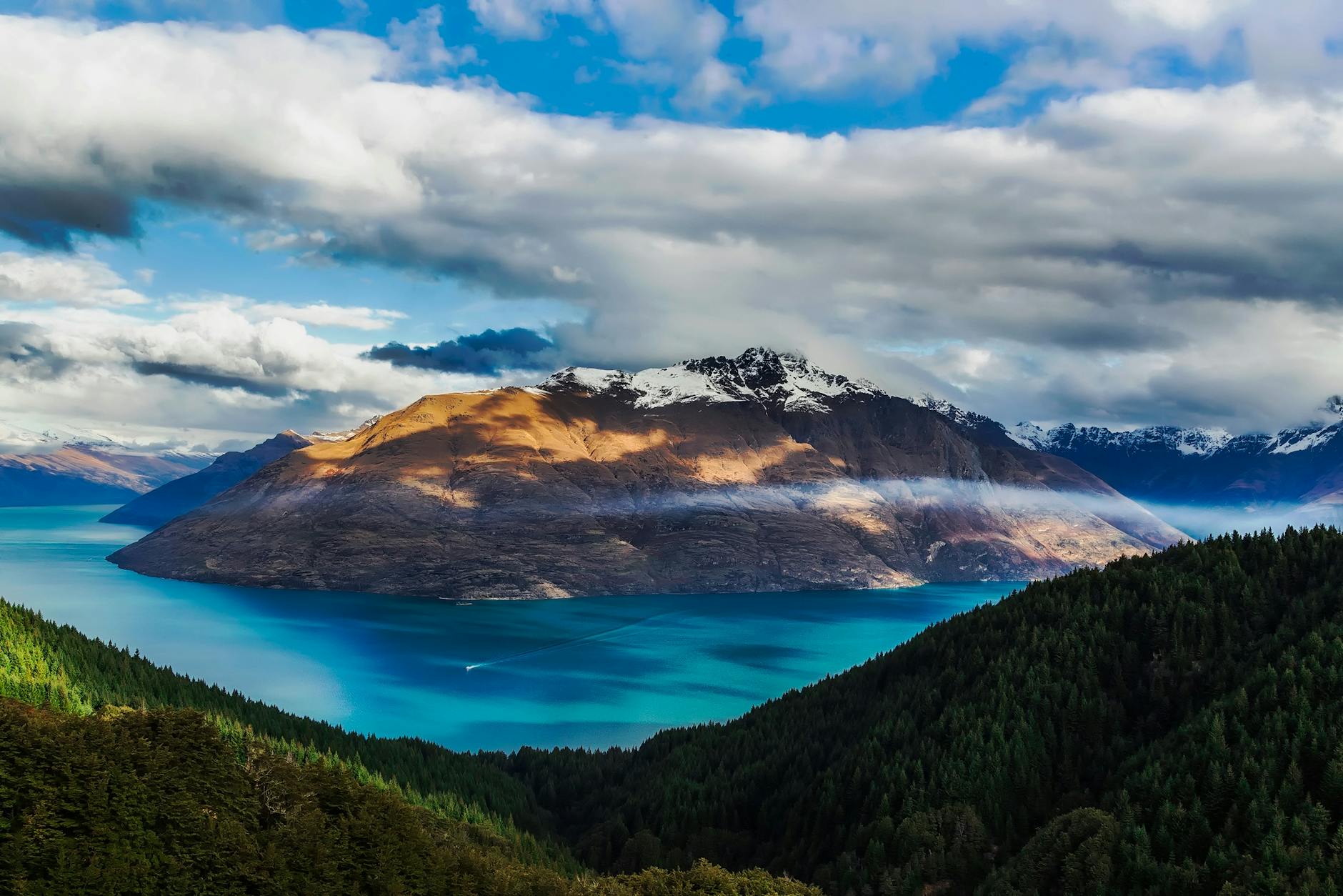 Aerial view of Queenstown with snow-covered peaks and surrounding valleys