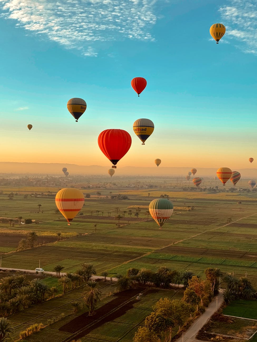 Colorful hot air balloons flying over Valley of the Kings at sunrise in Luxor, Egypt