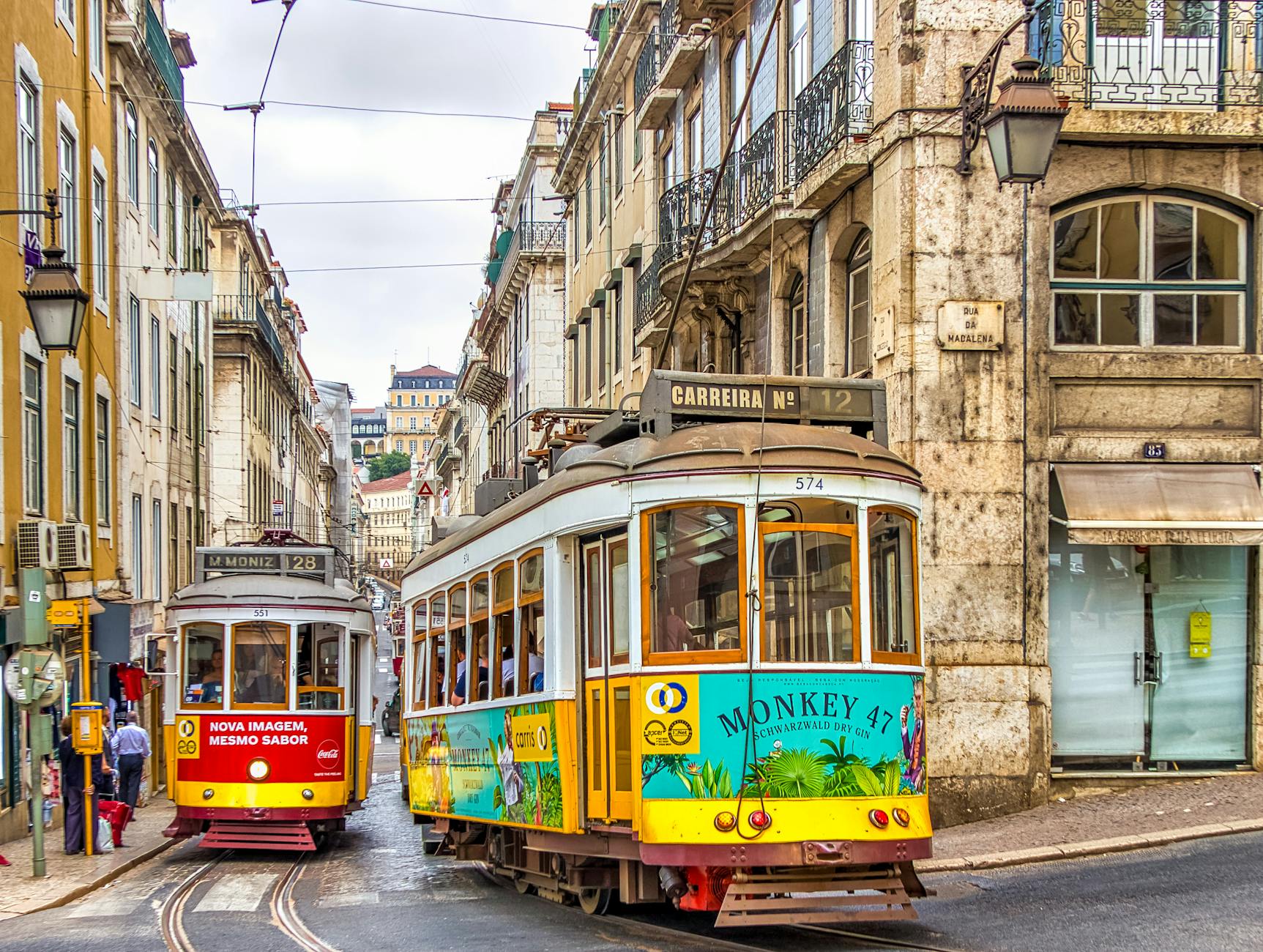 Historic yellow tram navigating narrow streets of Lisbon, Portugal