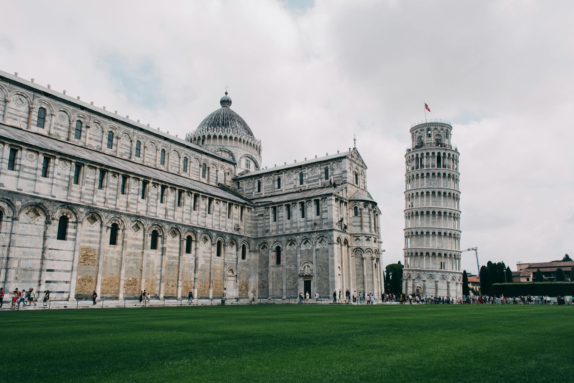 Leaning Tower of Pisa with clear blue sky and tourists taking photos