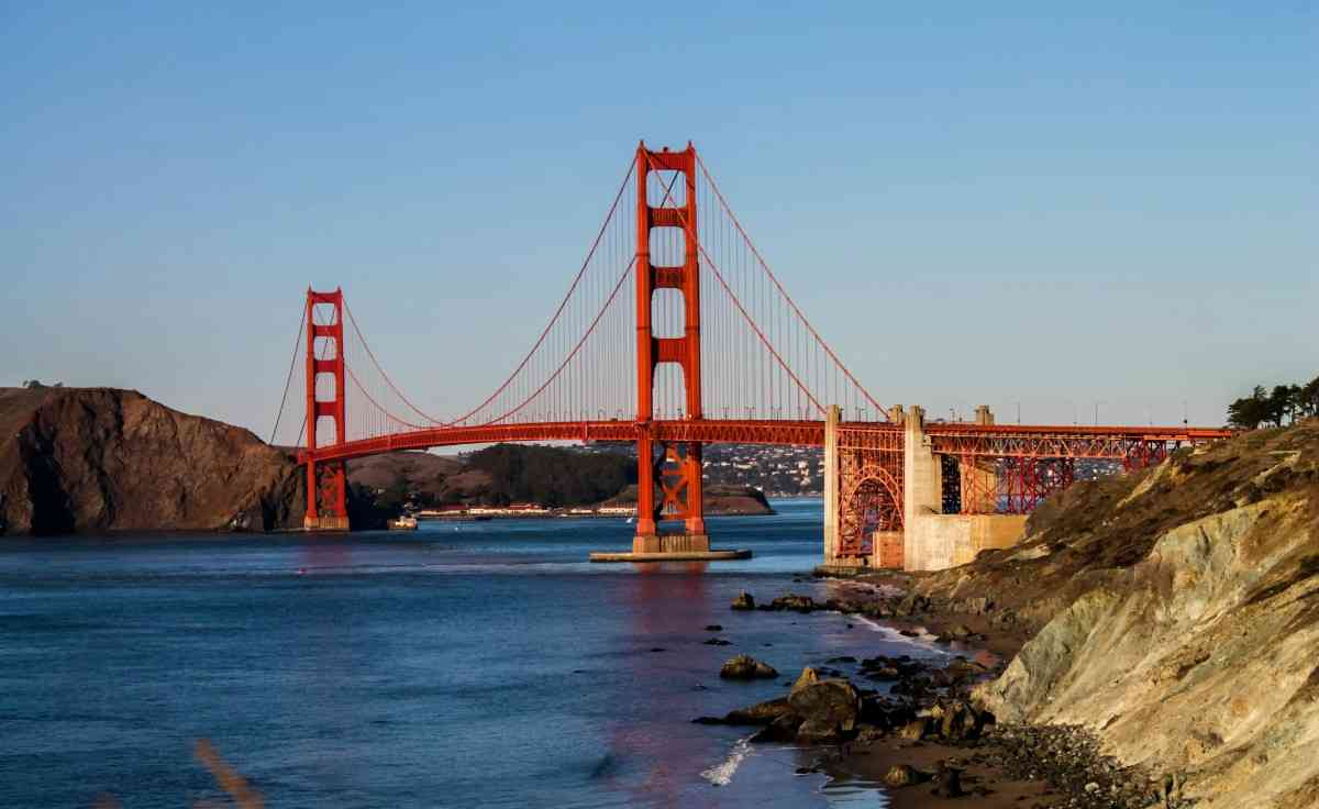 Golden Gate Bridge in San Francisco spanning the bay with fog rolling in, iconic red towers, and scenic waterfront views, a must-visit landmark in California.