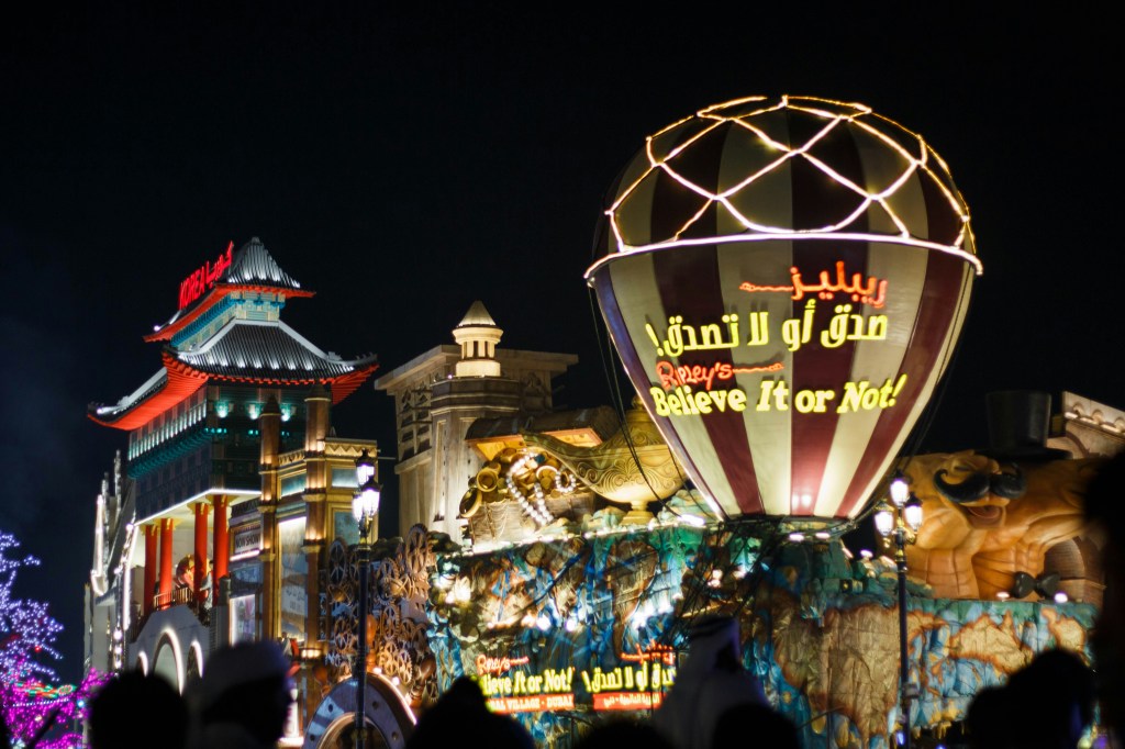 Night view of Dubai Global Village with colorful pavilions and lights