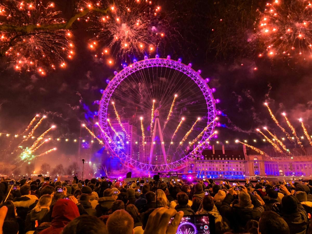 London Eye Thames New Year's Eve  fireworks with Big Ben chiming at midnight over river celebration