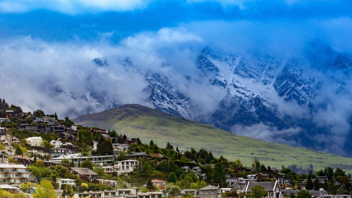 Aerial view of Lake Wakatipu surrounded by snow-capped mountains and adventure activities in Queenstown New Zealand