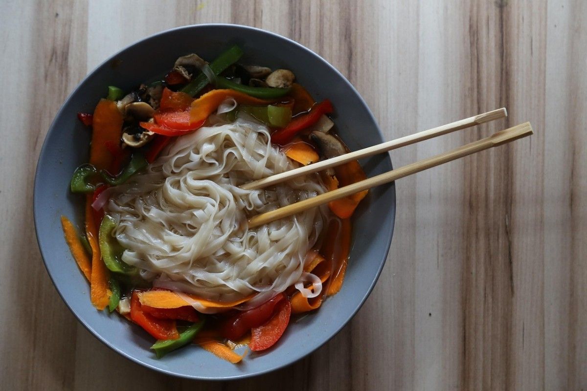 Bowl of vegetarian pho chay with tofu, fresh herbs, rice noodles, and aromatic broth