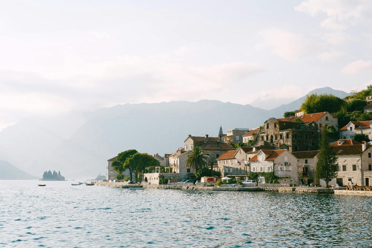 Panoramic view of the Bay of Kotor and medieval stone city walls during the 2026 Winter Carnival season.