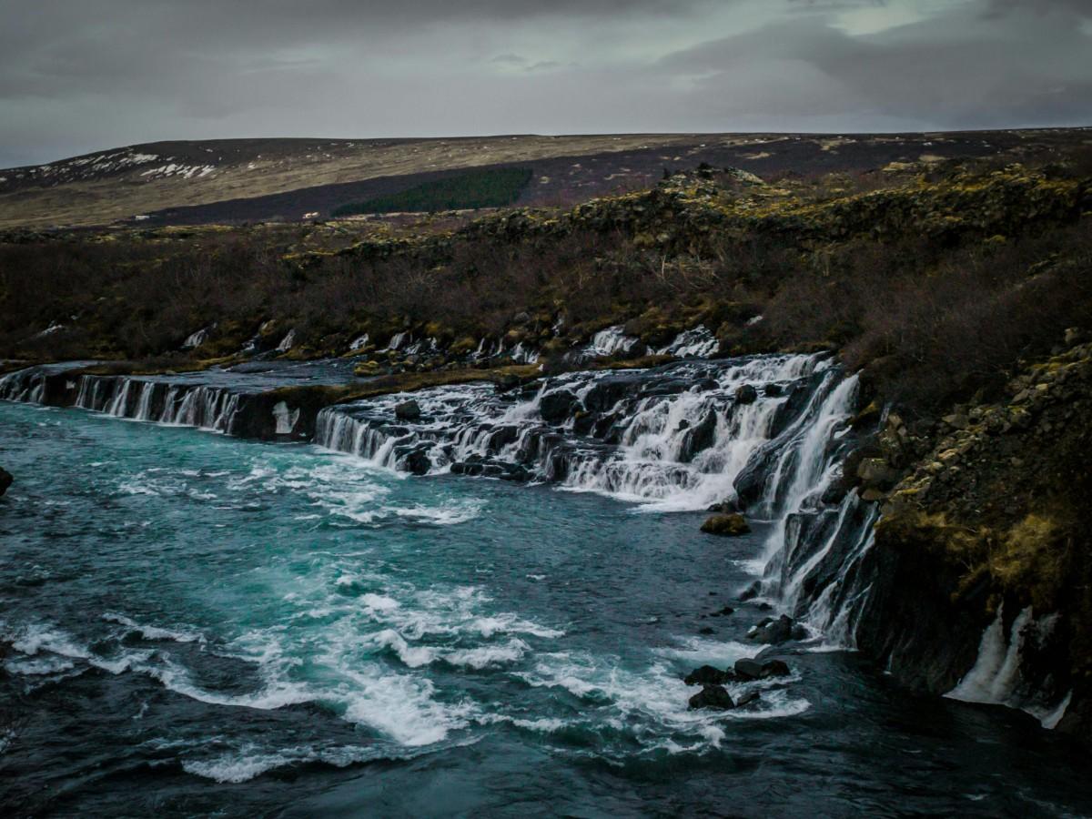 Scenic view of Iceland with waterfalls and rugged terrain in daylight
