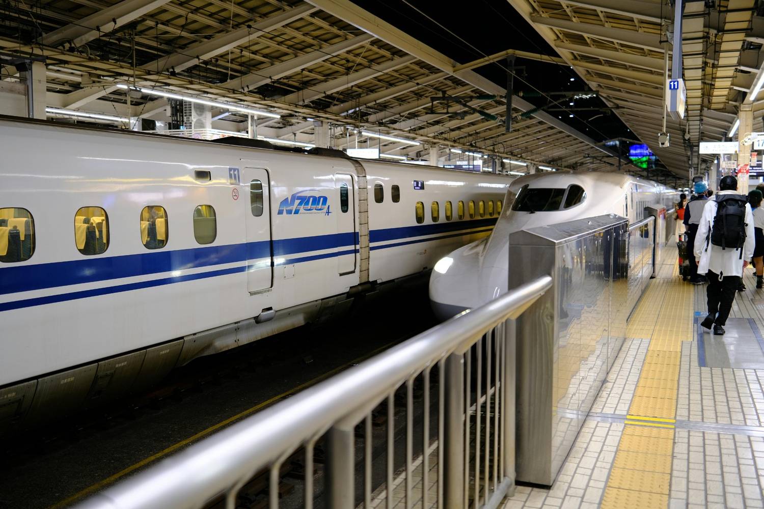 Metamong Ditto garden Shinkansen bullet train platform crowded with travelers during Golden Week Japan 2027